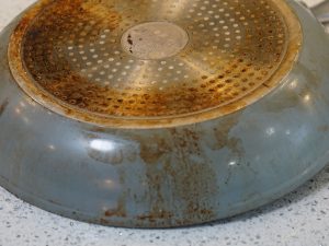 Machas de grasa quemada en un sartén de acero inoxidable